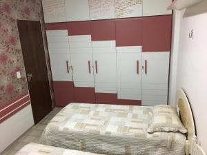 uma cama num quarto com parede vermelha e branca em Maravilhoso Apartamento - 175 m2 em Cabedelo