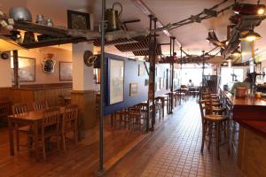 a restaurant with wooden tables and chairs and a bar at Hotel Metrokua in Lekeitio