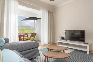 a living room with a couch and a tv at Jasmineiro II by An Island Apart in Funchal