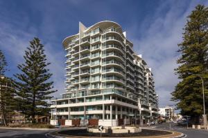 a tall white building with a curved roof at GlenelgApt in Adelaide