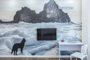 un perro parado en la nieve con una TV en una habitación en Apartments ODIN in city centre en Irkutsk