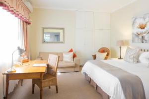 Habitación de hotel con 1 cama, escritorio y 1 dormitorio en Kingfisher GuestHouse, en Port Elizabeth