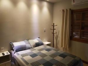 a bedroom with a bed and a window at Apartamento Bracuhy - Peninsula III in Angra dos Reis