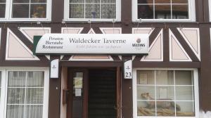 un bâtiment avec un panneau à l'avant dans l'établissement Waldecker Taverne, à Bad Arolsen