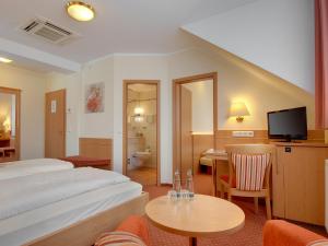 Postel nebo postele na pokoji v ubytování Hotel Kriemhild am Hirschgarten