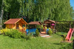 a backyard with a playground with a house and chairs at Zajazd Avena in Krokowa