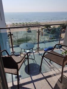 a balcony with a table and chairs and the beach at Biandada Apartments in Mamaia Sat/Năvodari