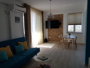 a living room with a blue couch and a table at Biandada Apartments in Mamaia Sat/Năvodari