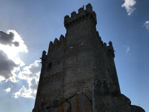 a castle tower with a blue sky in the background at Hotel Medieval® de Penedono in Penedono