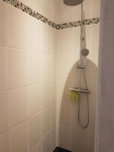 a bathroom with a shower with white tiles at Appartement Cap Horn in Le Mont-Dore +23 photos