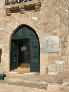einen Eingang zu einem Gebäude mit grüner Tür in der Unterkunft Hotel Medieval® de Penedono in Penedono