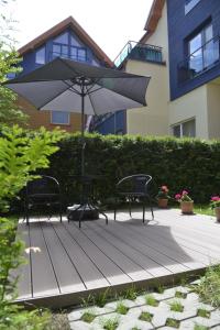 a table and chairs and an umbrella on a deck at Apartment rent in Nida