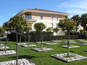 アンティーブにあるLes jardins d'Antibesの建物前のオレンジの木が植えられた庭園