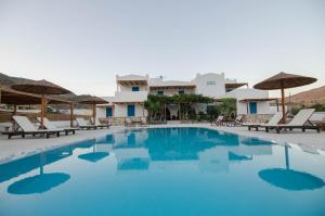 a pool at the resort with chairs and umbrellas at Villa Maria in Ios Chora