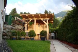 a wooden pergola with potted plants in a yard at Apart Alblittblick in Kappl