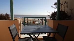 - une table et des chaises noires avec vue sur la plage dans l'établissement Résidence TROUVILLE, à Châtelaillon-Plage