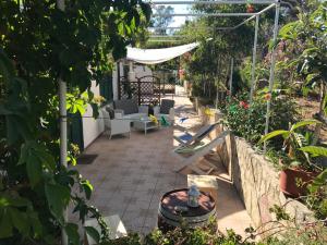 a garden with a patio with chairs and a table at Casa Bianca Rais Gerbi in Finale