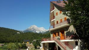 Ein Gebäude mit einer Treppe darauf, im Hintergrund Berge in der Unterkunft Vila Dini in Valbonë