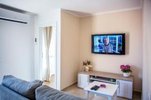 uma sala de estar com um sofá e uma televisão na parede em Emma appartment em Porec