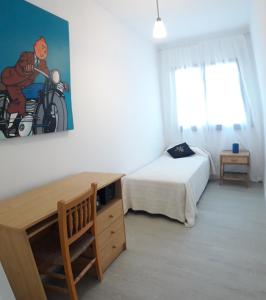 ein Schlafzimmer mit einem Bett und einem Schreibtisch sowie einem Bett und einem Bett in der Unterkunft apartament Sant Pere in Sant Pere Pescador