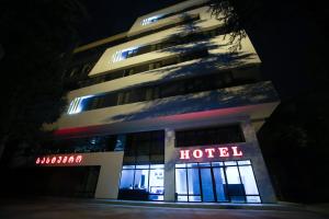 um edifício de hotel com um sinal de hotel à noite em West Tower Hotel em Kutaisi