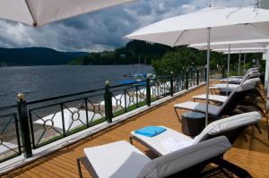 una terrazza con sedie e ombrelloni in acqua di Treschers Schwarzwald Hotel a Titisee-Neustadt