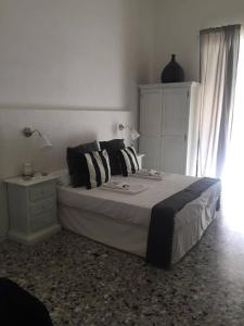 sypialnia z dużym łóżkiem i białą szafką w obiekcie Chiaia House w mieście Napoli