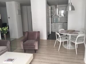a kitchen and a living room with a table and chairs at Calle Aduana in Madrid