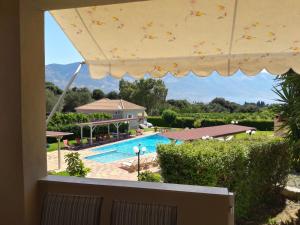 a view from the balcony of a house with a swimming pool at Residence Poseidon in Spartià
