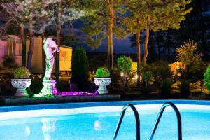 una piscina por la noche con una fuente en Holiday Lodge en Pogorzelica