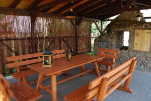 a wooden picnic table and benches in a pavilion at Kamienna Zagroda in Białowieża