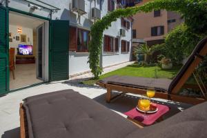 a patio with a bed and two wine glasses on a table at City Center Apartment Kadena in Split