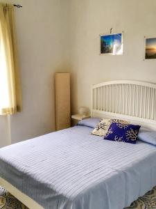 um quarto com uma cama grande e lençóis azuis em Eden Apartment em Anacapri