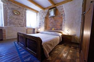 a bedroom with a bed and a brick wall at House Trevisol in Rovinj