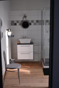 a small bathroom with a sink and a chair at La maison de Thiré in Thiré +16 photos