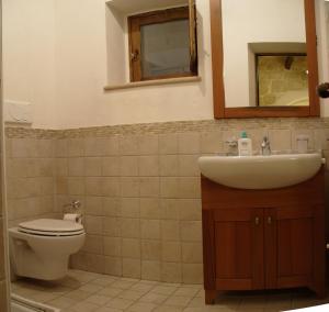 een badkamer met een wastafel, een toilet en een spiegel bij Agriturismo Zizzi in Ceglie Messapica