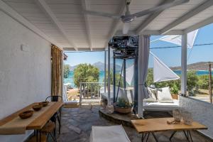 a patio with a table and a view of the ocean at Papikinou Bay Suites in Adamas