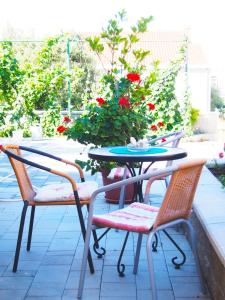 un tavolo da patio con sedie, tavolo e fiori di Apartment Nives a Zara (Zadar)
