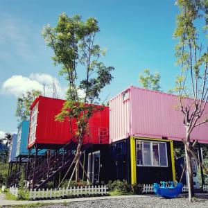 a row of colorful houses sitting next to trees at 蔓條絲裡Slow Motion B&B in Yuchi