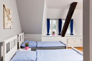 two beds in a room with blue curtains at Bett4-you Pinneberg - Prisdorf in Prisdorf