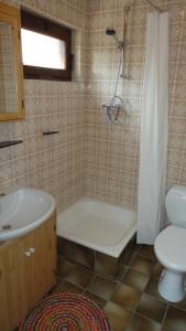 een badkamer met een bad, een toilet en een wastafel bij Lardinois vakantieverhuur in Beutenaken