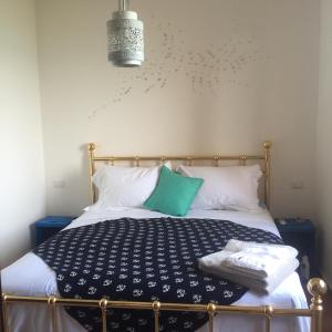 a bedroom with a bed with a blue and white comforter at Beach Front Villa-Families & Pet Friendly in Porto Santo Stefano