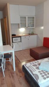 a room with a bed and a table and a kitchen at West City Apartments in Budapest