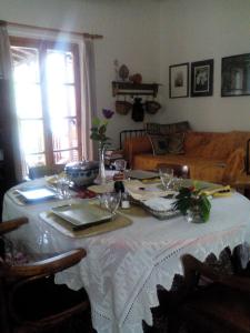 a table with a white table cloth on it in a living room at Nightingale Cottage Pelion in Kalamaki