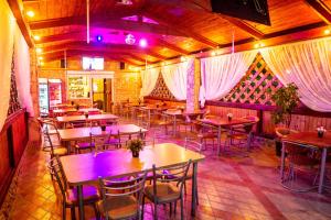 un restaurante con mesas, sillas y luces púrpuras en Assol, en Gelendzhik