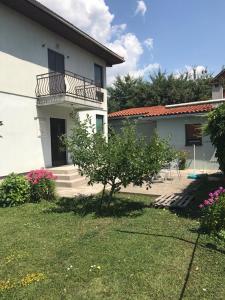 a white house with a balcony and a yard at Guesthouse Vujacic in Cetinje