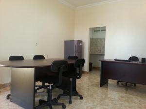 an office with a table and chairs and a refrigerator at Discovery Homestay in Makassar