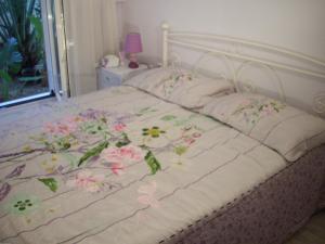 a white bed with flowers on it with at Lilly's Appartments in Athens