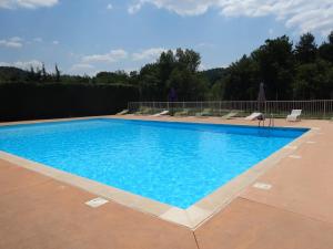 a swimming pool with blue water on a patio at Golf Resort de Digne-les-Bains by Adonis in Digne-les-Bains