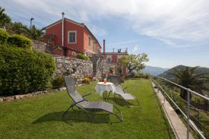 a table and chairs on the grass in front of a house at Rosso su Portofino in Chiavari